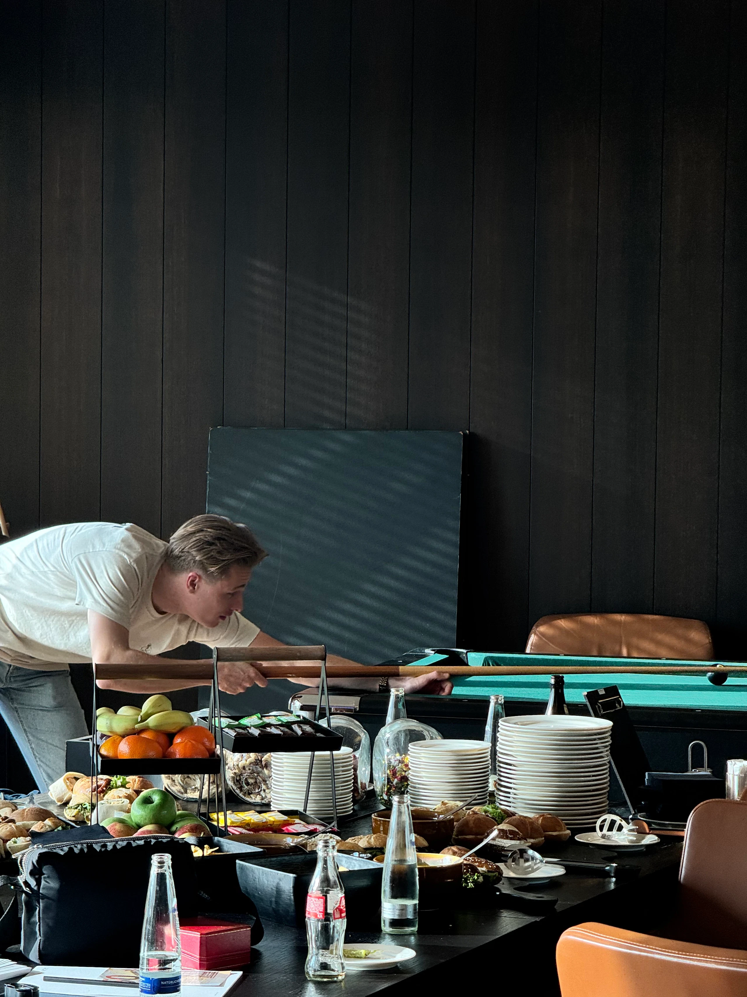 A dealer taking a shot at the pool table behind the buffet