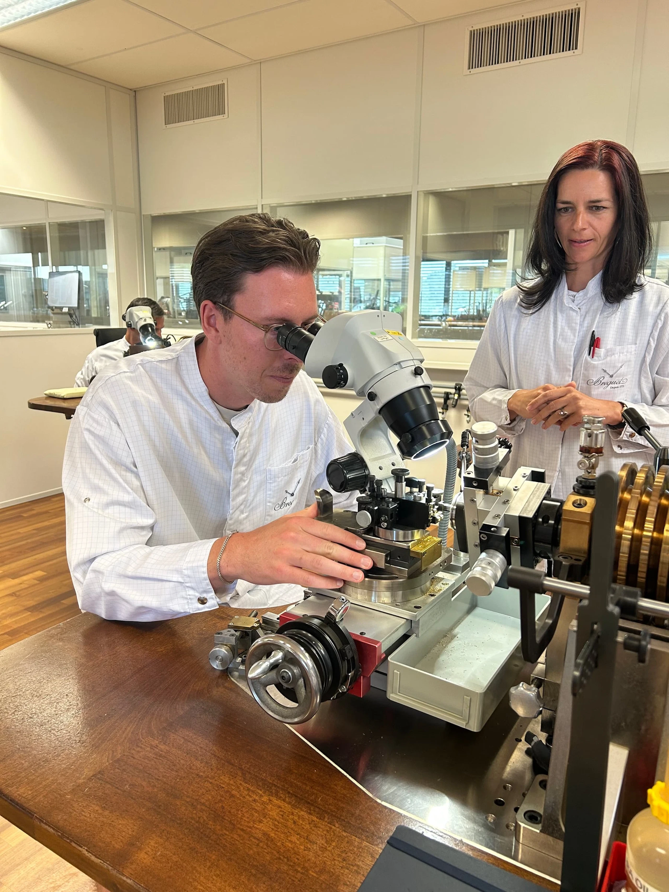 A watchmaker at a microscope in the Breguet manufacture