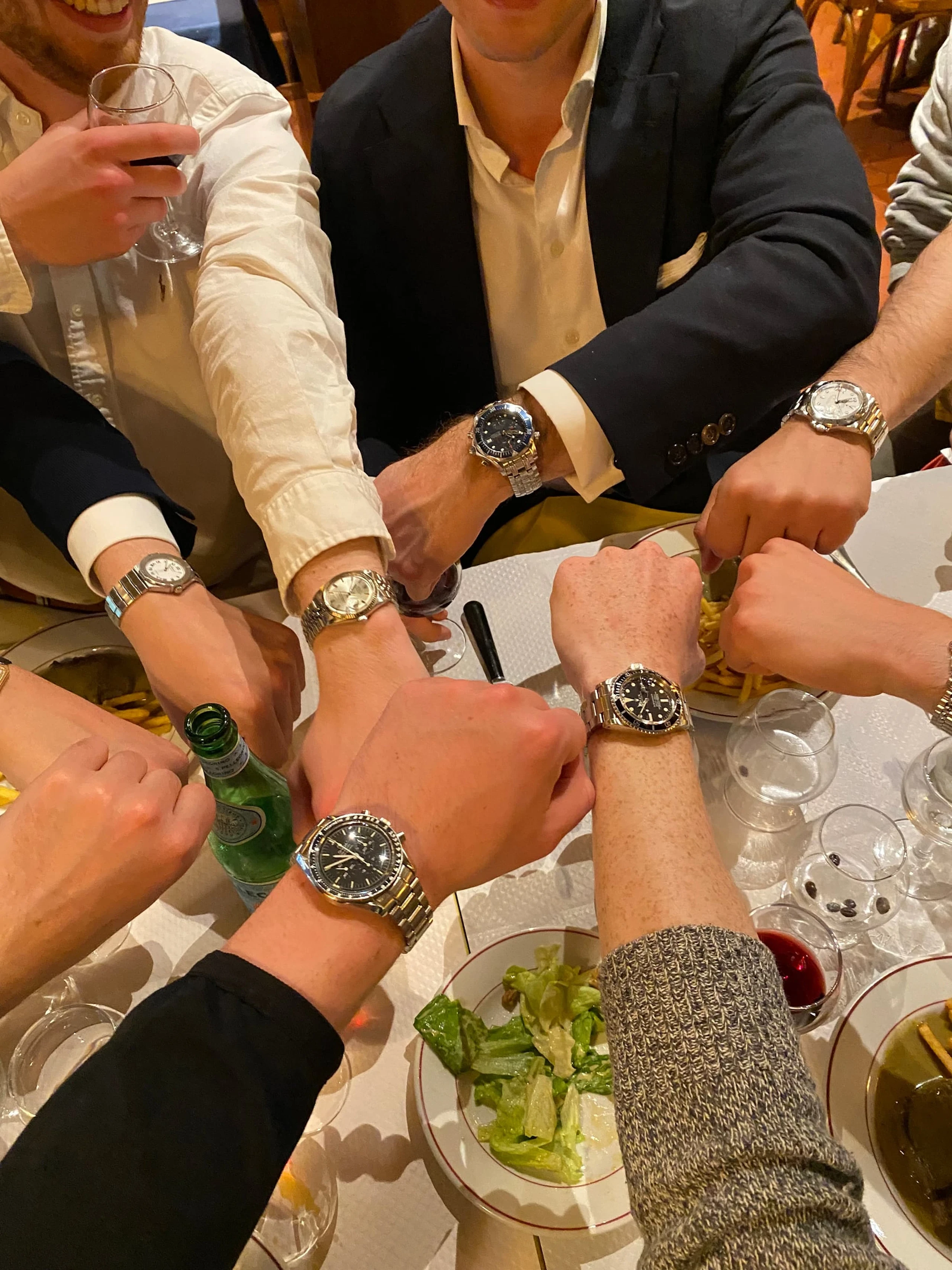 A circle of dealers’ wrists at a table in Geneva, showing the watches they wore