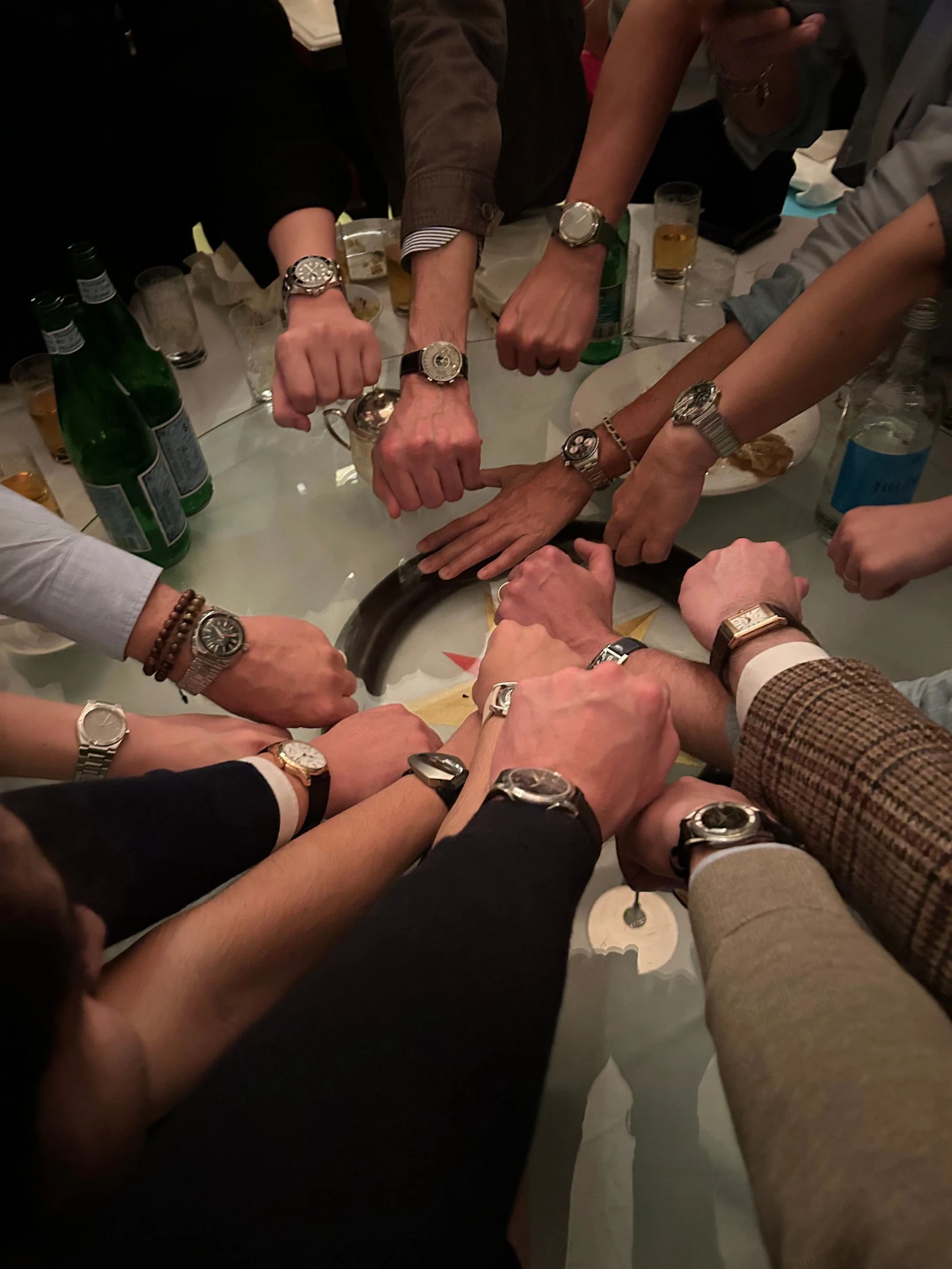 Dealers’ wrists meeting over a table in Hong Kong, each wearing a watch