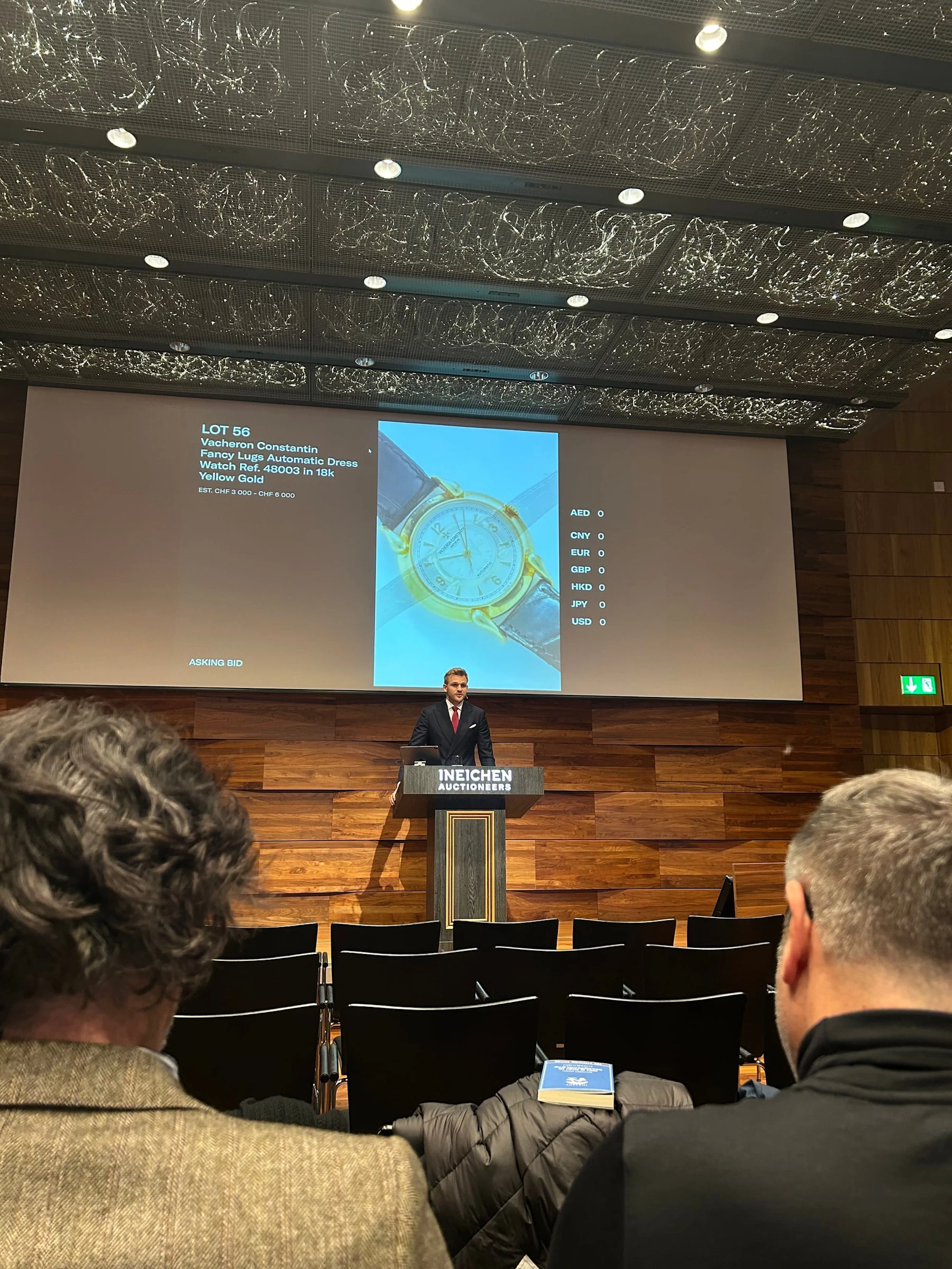 A speaker presenting at an Ineichen Auctioneers evening in Zürich
