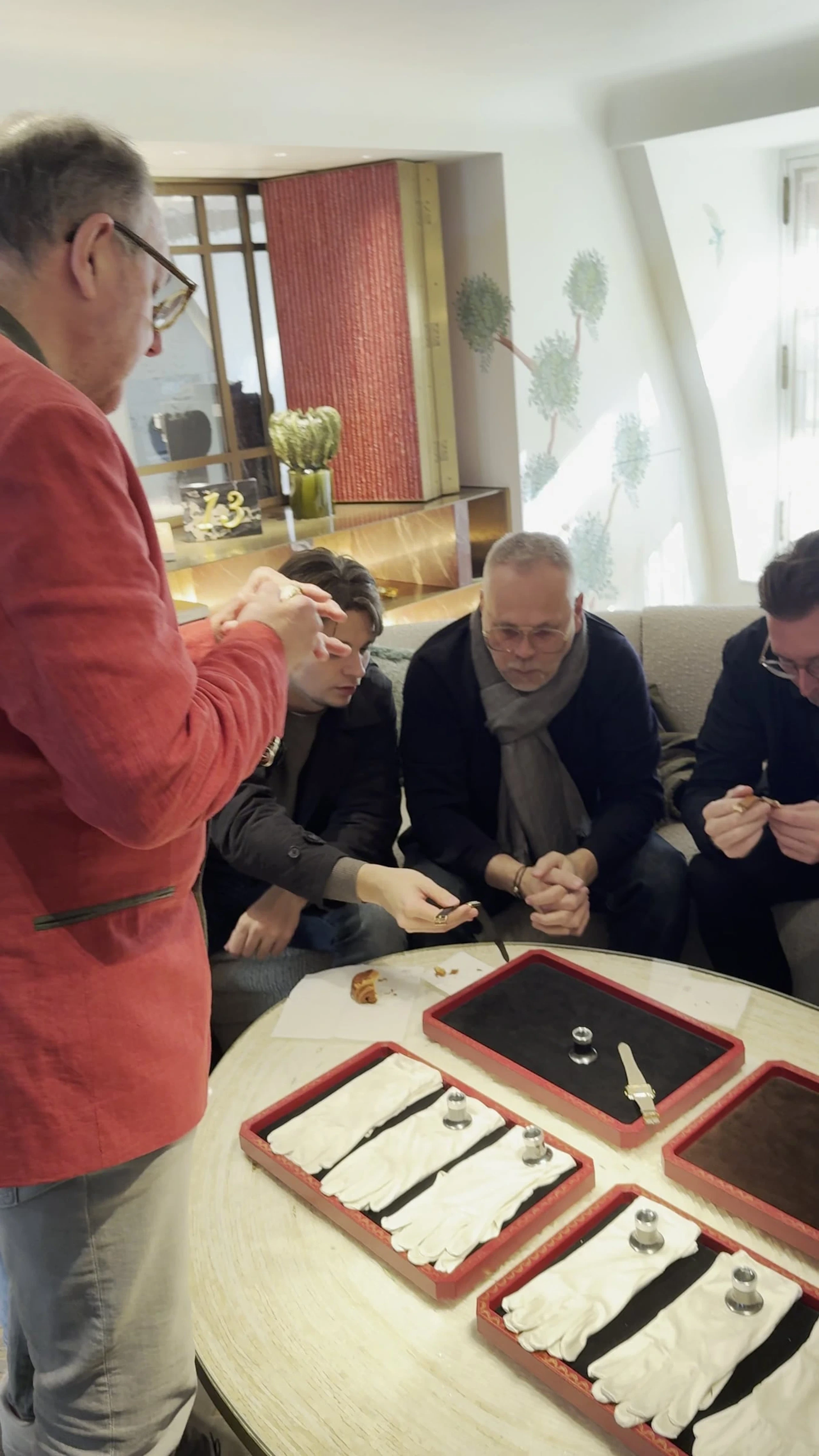 Dealers seated around trays of Cartier watches