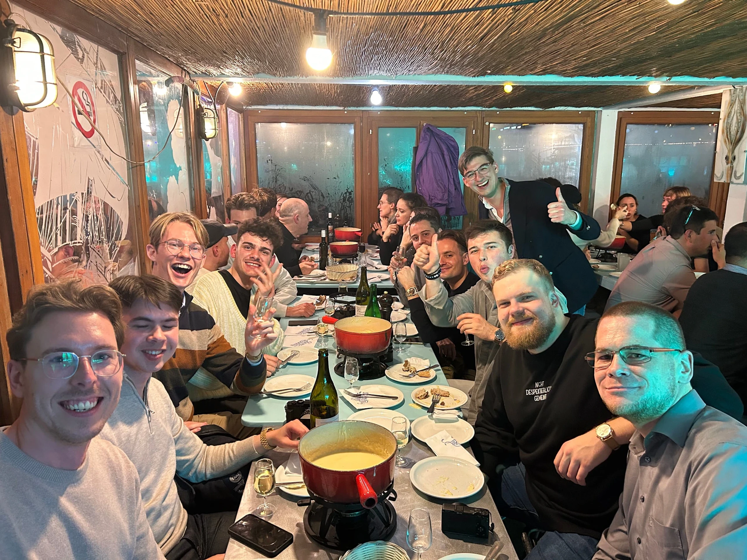 A long table of dealers at dinner in Geneva, smiling for the camera