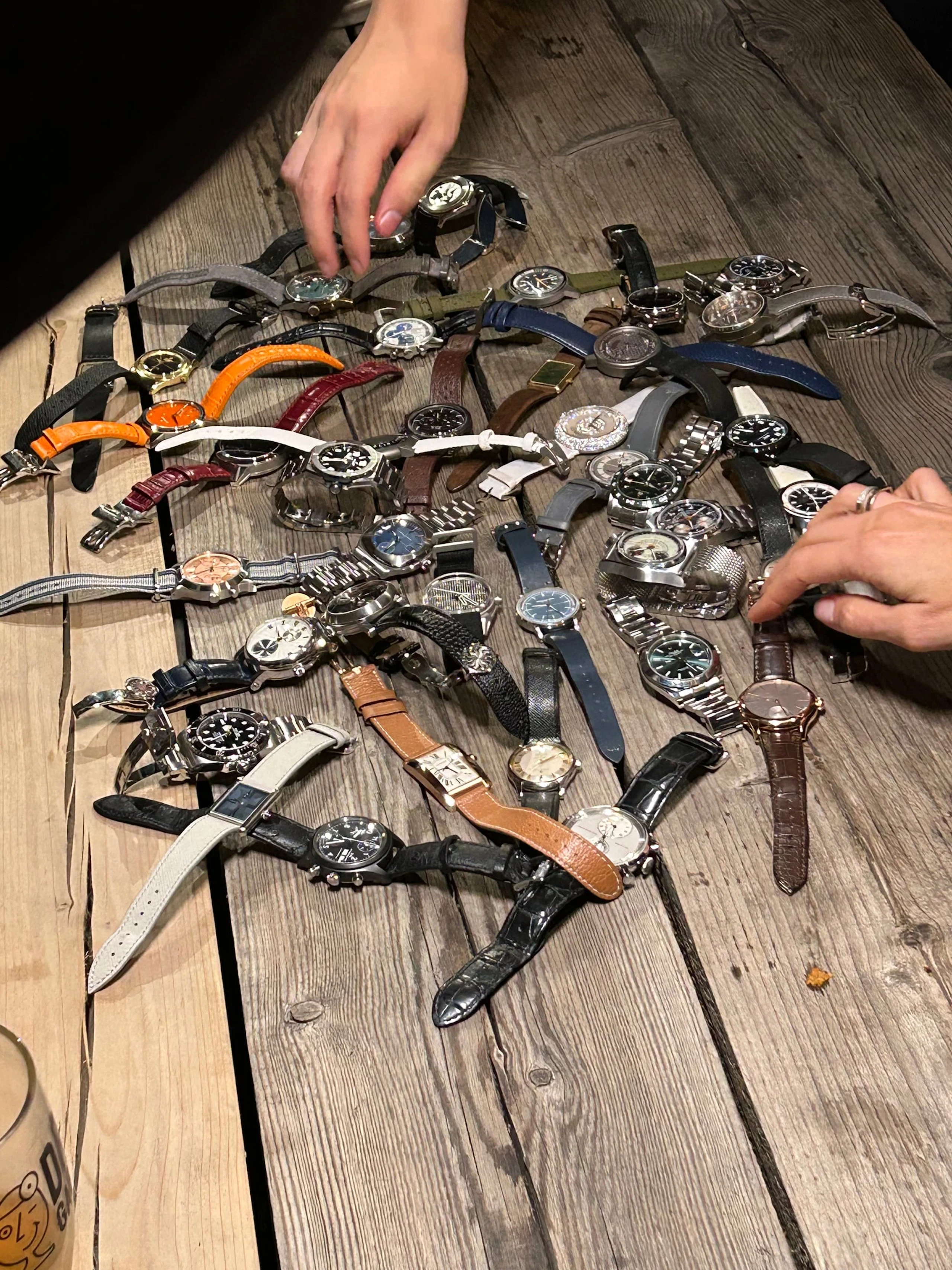 Dozens of watches spread across a wooden table in Geneva