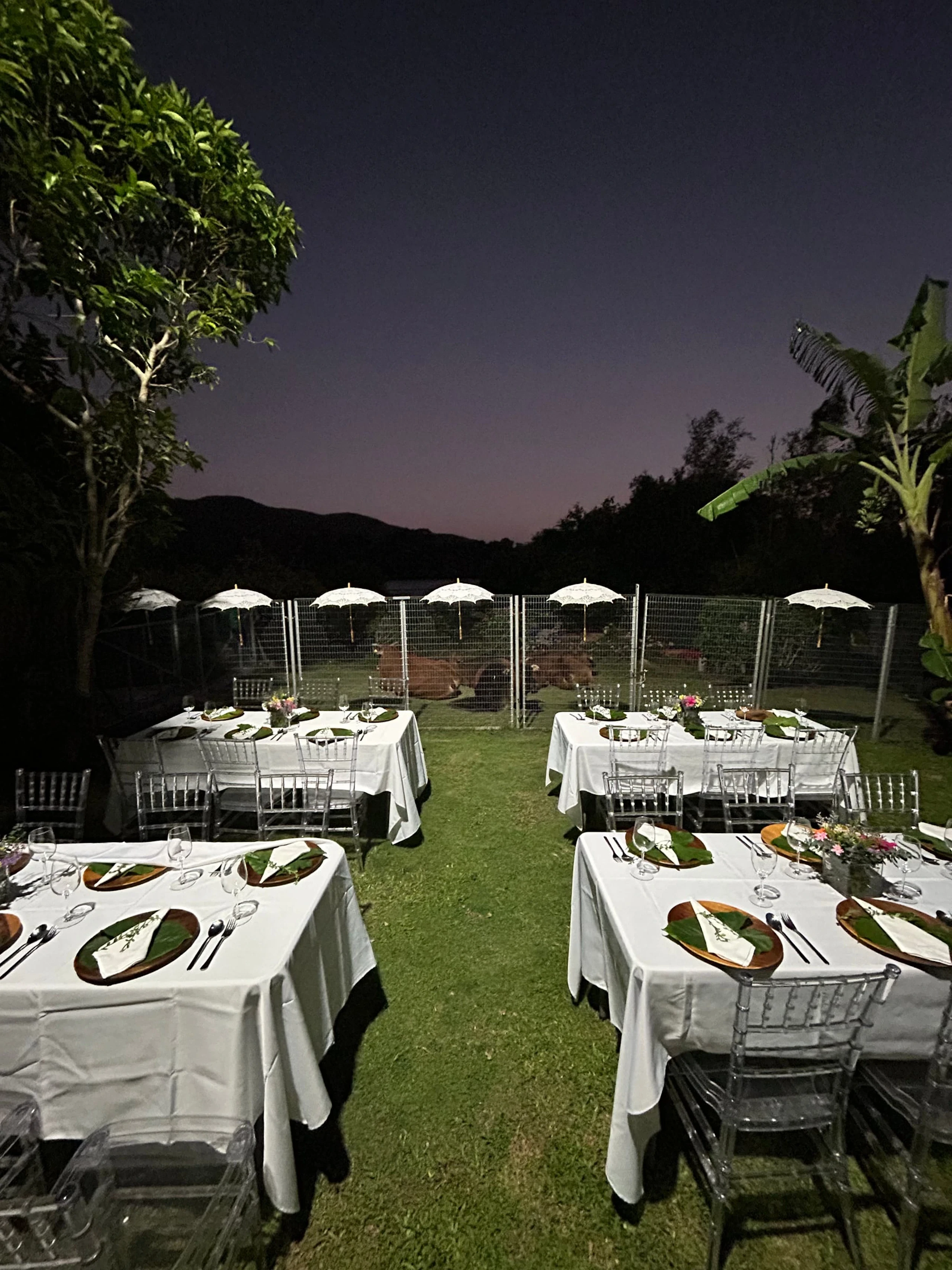 Tables set for dinner on a lawn in Hong Kong at dusk